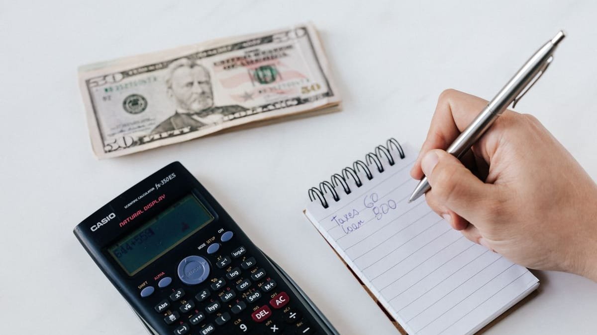 Hand with a calculator and notes budgeting a project
