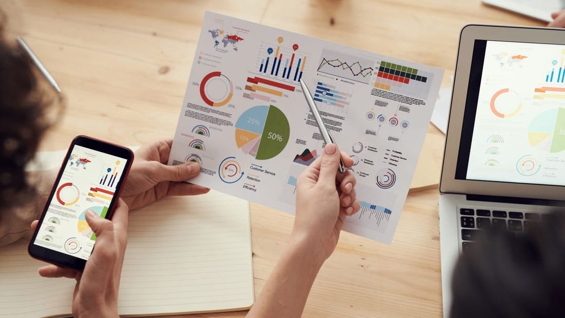 Hand pointing to a performance chart in a meeting