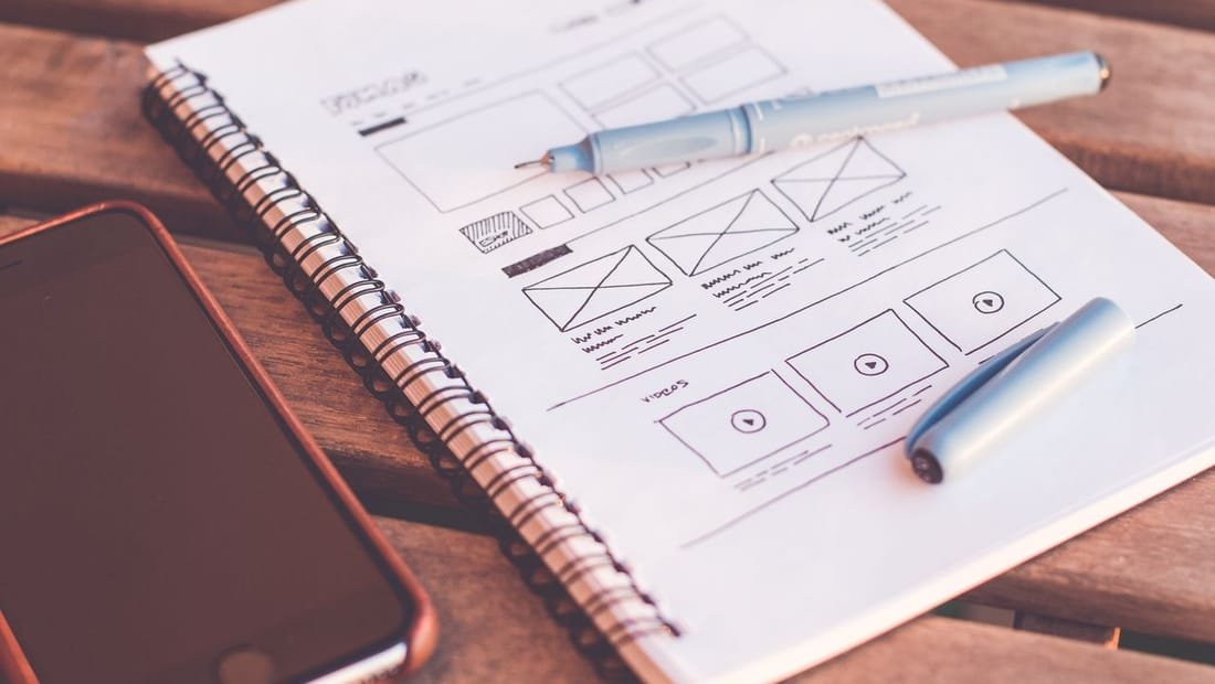 Project plan and blueprint sketches on a notepad